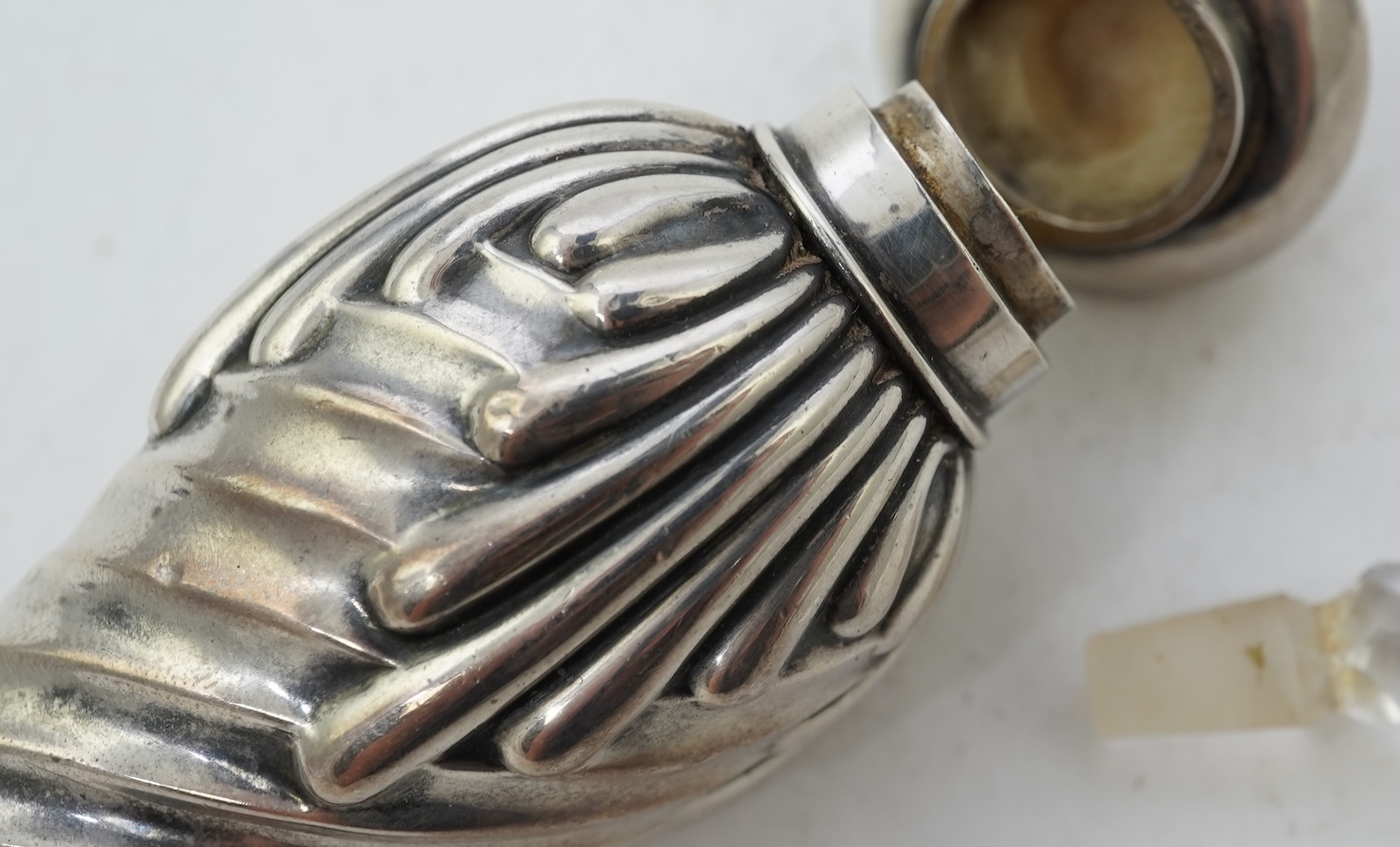 A late Victorian silver scent flask, of spiral tear drop form, with hinged cover and glass stopper